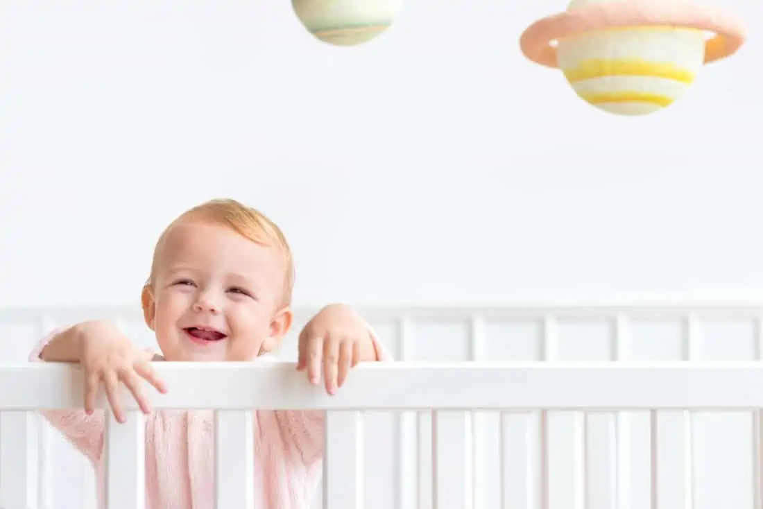 Baby staat in bed
